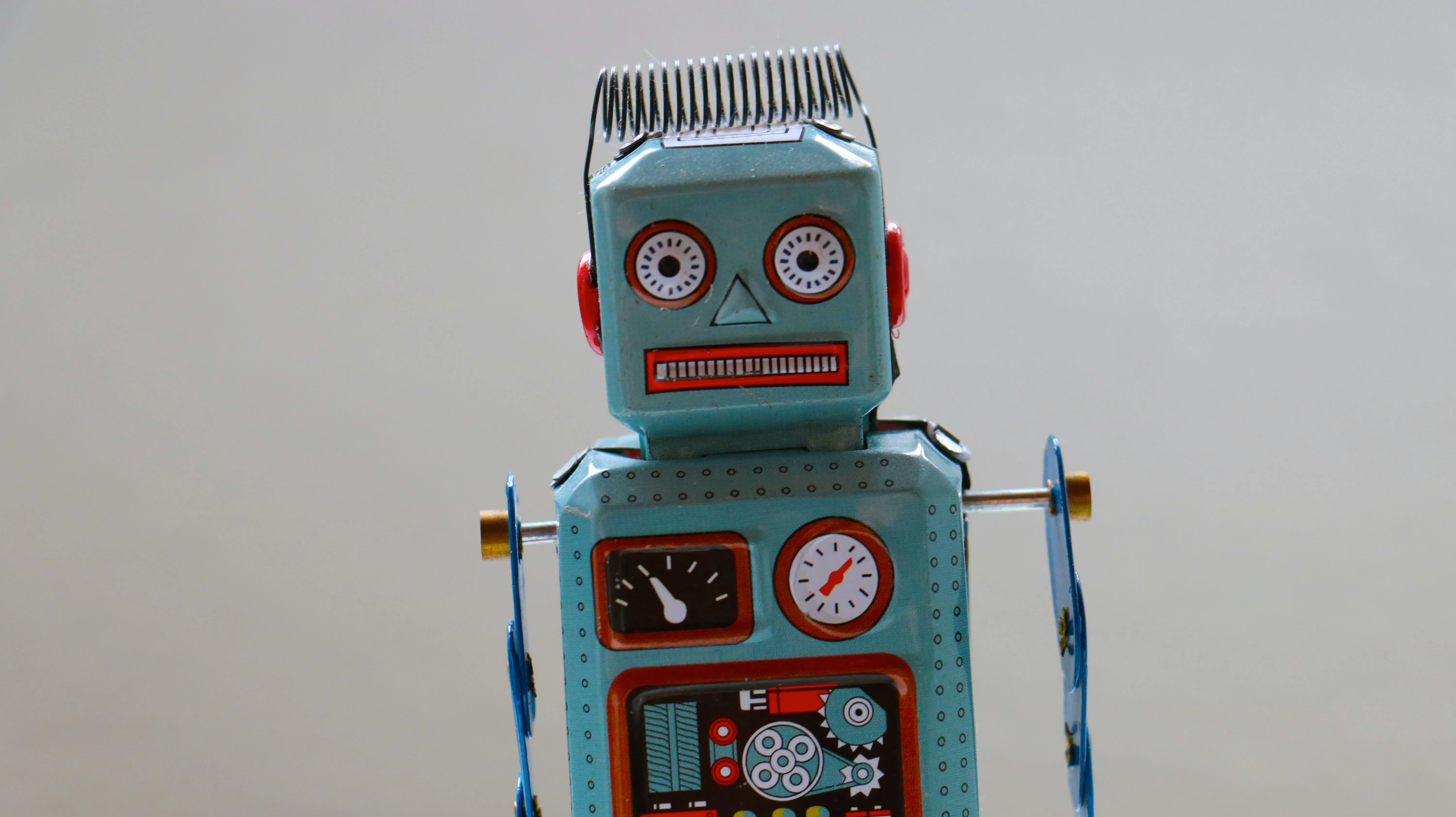 Vintage tin robot toy on a white background exemplifying functional programming principles in Python, symbolizing the automation and precision of code.