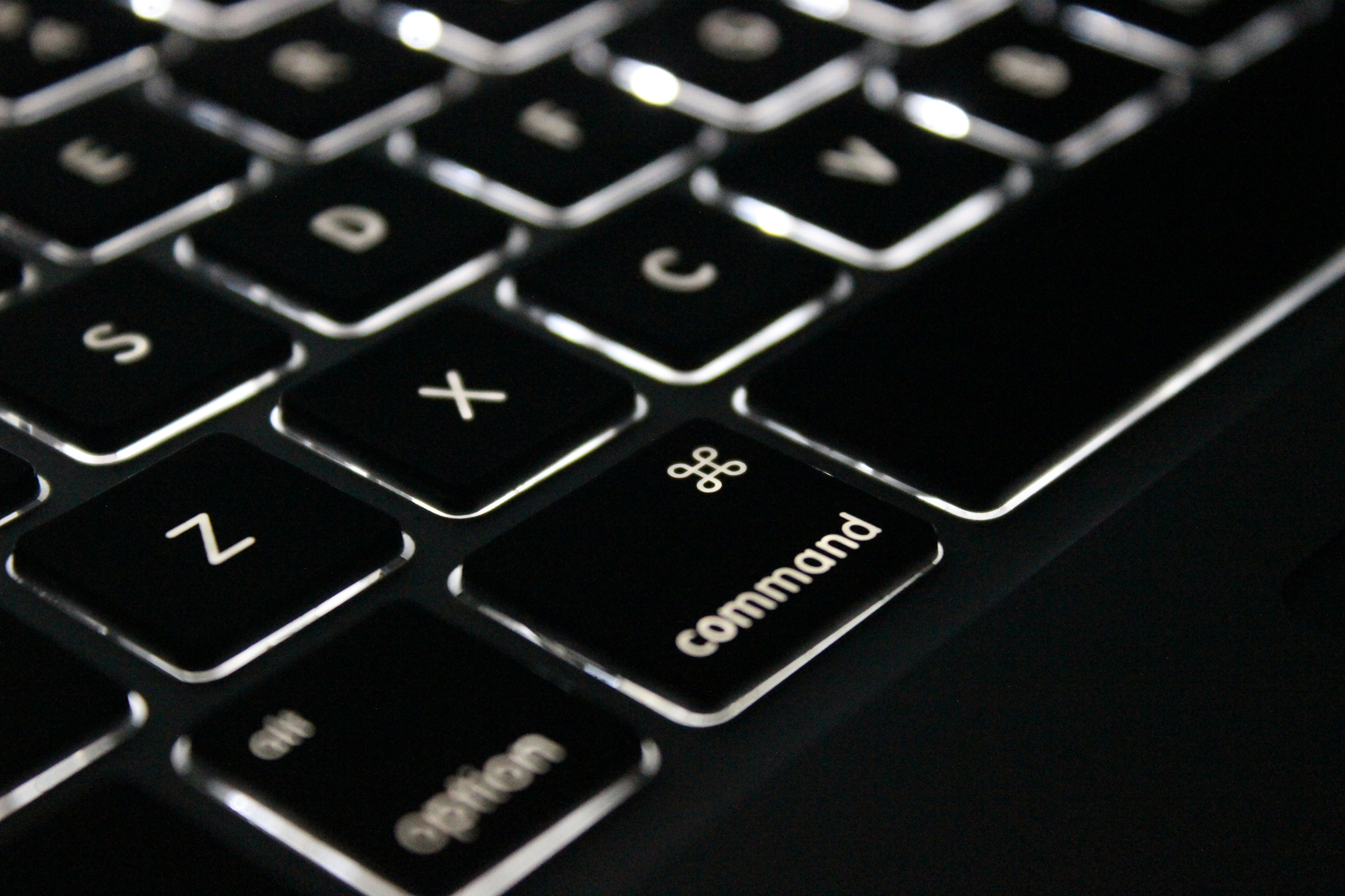 Close-up of a backlit keyboard with the Command key highlighted, illustrating the Python Command design pattern tutorial for scalable applications.