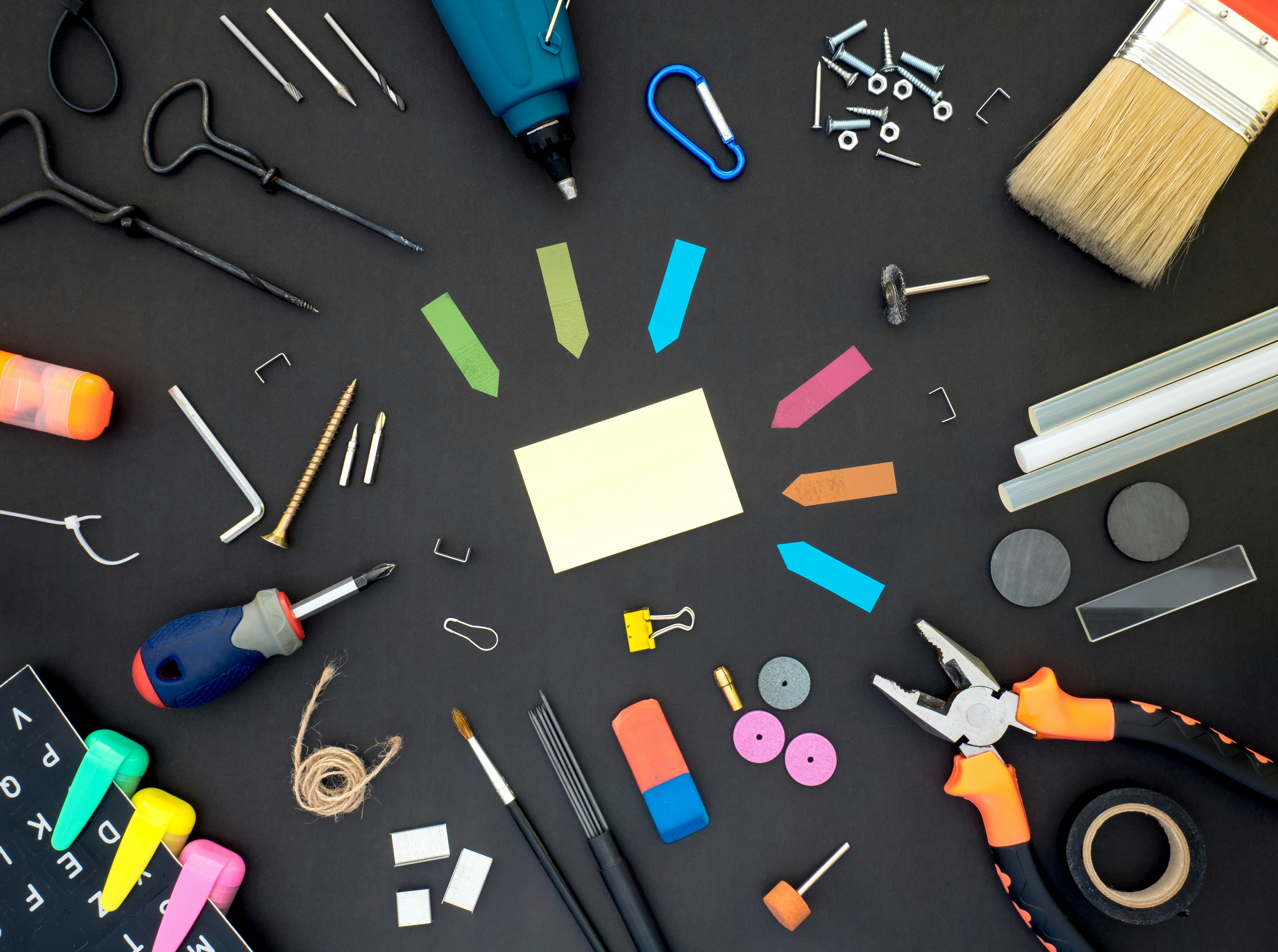 A variety of tools arranged on a black surface, including a screwdriver, drill, pliers, paintbrush, and various hardware. This image symbolizes the versatility and efficiency of the Python functools module for code optimization, showcasing how different tools can enhance coding projects.